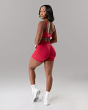 Woman wearing a red sports outfit on a gray background