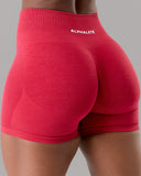 Red athletic shorts with 'Alphalete' branding on a gray background